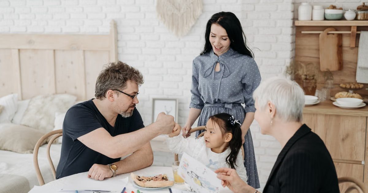 Child with foster parents and a social worker discussing adoption at home.